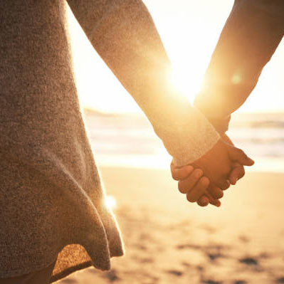 Rearview shot of an unrecognizable couple holding hands while at the beach